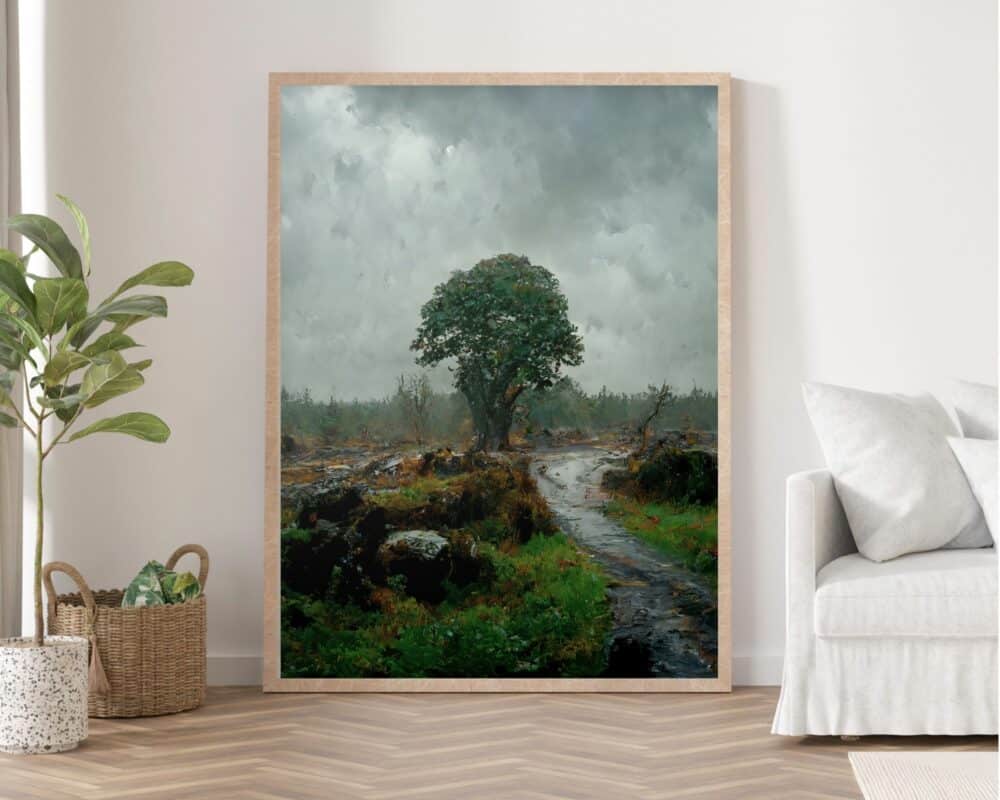 תמונה לחדר שינה סגנון ציור וינטג נוף טבע יער גשום עומדת על קיר. הציור, הממוקם במסגרת עץ, מתאר סצנה גדולה של עץ בודד על שביל עשב תחת שמים מעוננים, והוא ממוקם בחדר מינימליסטי עם ספה בז', עציץ וסלסלה ארוגה.