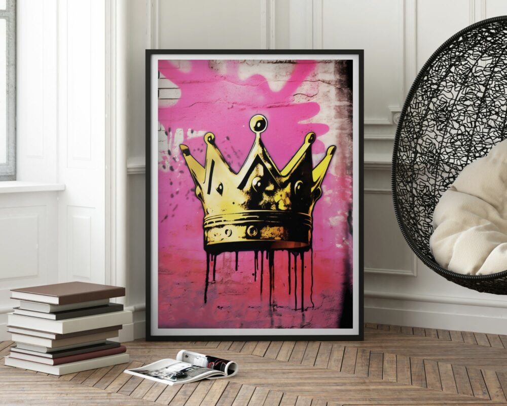 יצירת אמנות ממוסגרת שכותרתה "תמונה לחדר נוער בעיצוב גרפיטי כתר זהב על רקע ורוד" מושענת על קיר עם לוח לבן בחדר מודרני. החדר כולל כיסא תלוי שחור עם כריות לבנות וערימת ספרים על רצפת העץ.