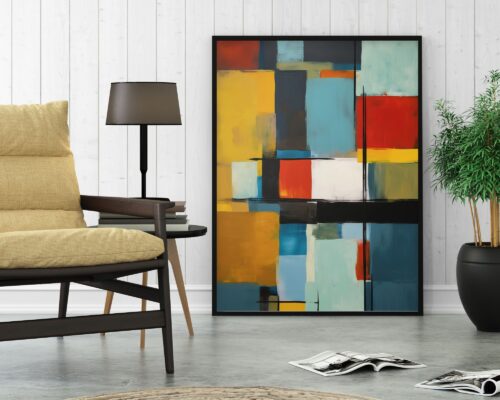 סלון מודרני כולל כורסה בצבע בז' ושולחן צד קטן מעץ עם מנורה שחורה. ציור אבסטרקטי גדול, תמונה למשרד נוסח אבסטרקט בלוקים צבעוניים, מונח על הקיר הלבן. על הרצפה מונח מגזין פתוח לצד עציץ.