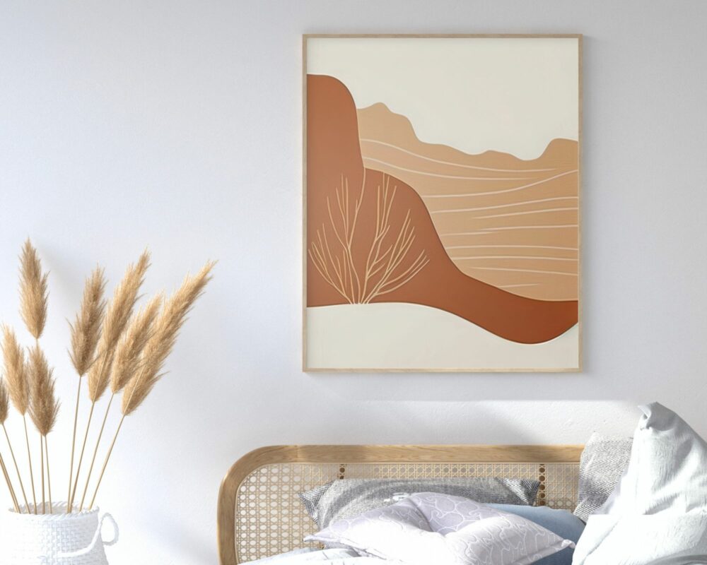 חדר שינה מואר כולל ראש מיטה מקש בז', כריות בצבע אפור ולבן, אגרטל לבן עם גבעולי חיטה מיובשים, ותמונה לחדר שינה נוסח בוהו שיק נוף הרים מדברי בצבעי בז' וחום על הקיר. האמנות מתארת נוף מינימליסטי בגווני אדמה חמים המורכב מבז', חום ושזוף.