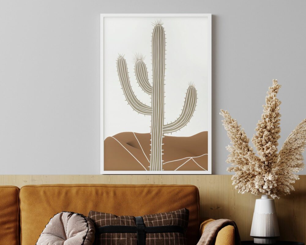 סצנת פנים מודרנית הכוללת ספה בז' עם כרית שחורה ושמנת, משענת עץ ואגרטל של פרחי בז' מיובשים בצד. מעל, תמונה לחדר שינה בעיצוב בוהו שיק של קקטוס במדבר תלוי על קיר אפור בהיר.