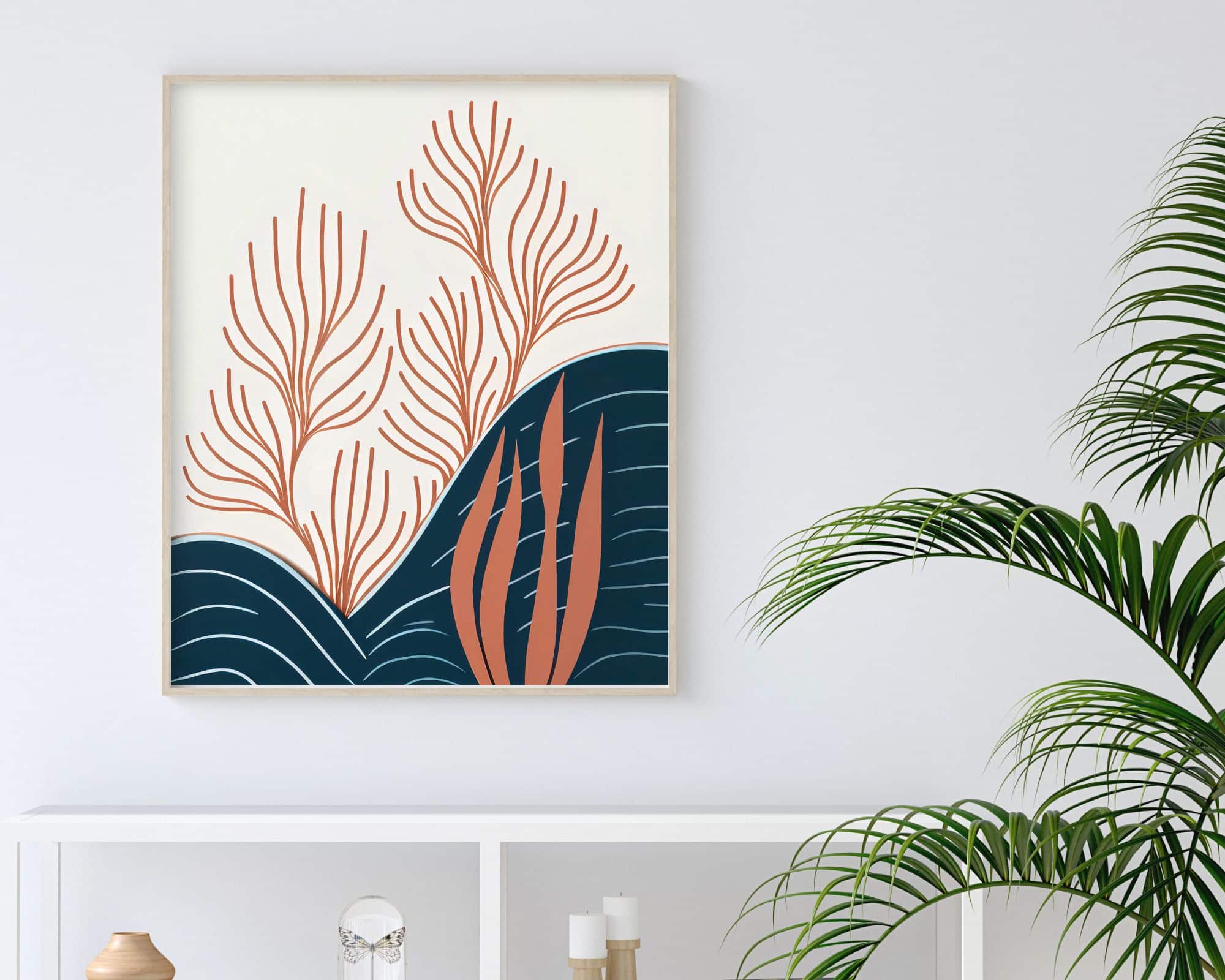 9299mo1 יצירת אמנות ממוסגרת בשם "תמונה לחדר שינה נוסח בוהו שיק אלמוגים כתומים מתחת לגלי ים", הכוללת מוטיבים צמחיים מופשטים בגווני כתום וכחול נייבי, תלויה על קיר לבן מעל מדף לבן. המדף מכיל פריטי נוי, ומימין מונח צמח ירוק בעל עלים ארוכים ודקים.