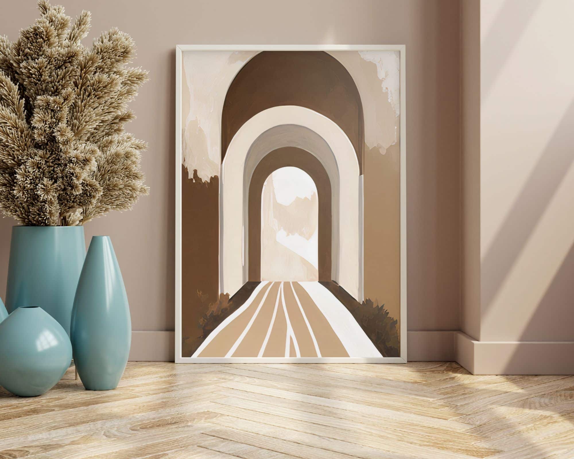 9292mo1 תמונות ממוסגרות sich im Boho-Schick-Stil הכוללות קשתות בגווני חום ובז' מונחות על קיר בז'. לצדו שני אגרטלים כחולים - אחד גבוה עם סידור פרחים מיובש ואחד קצר - מונחים על רצפת עץ בהירה בדוגמת אדרה.