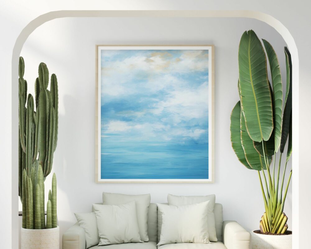 סלון שליו עם קירות לבנים כולל ספה בצבע ירוק פסטל עם כריות תואמות. קקטוסים גבוהים מציפים את הצד השמאלי, בעוד שצמחי בית גדולים ובעלי עלים מעטרים את ימין. מעל הספה תלויה "תמונה לחדר שינה בסגנון אבסטרקט גלים ושמיים עם עננים" ממוסגרת.