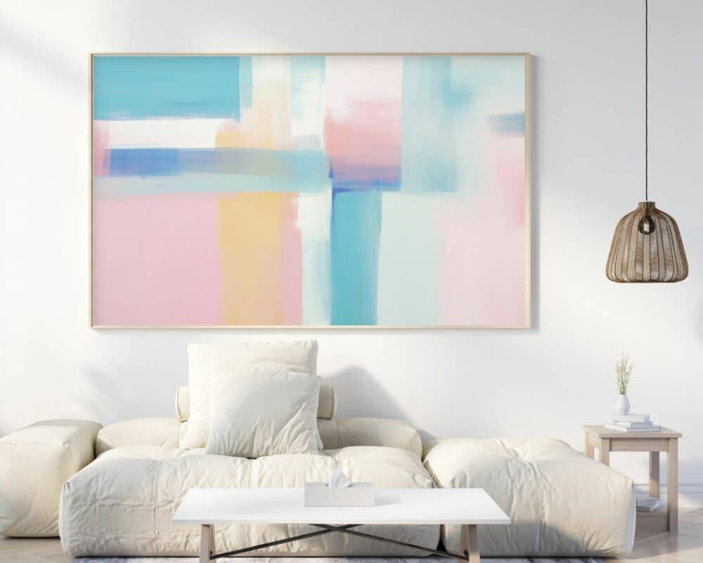 סלון מינימליסטי עם ספה לבנה מרופדת ושולחן קפה לבן מלפנים. מעל הספה תלויה תמונה לחדר שינה מעל המיטה משיכות מכחול בצבעי פסטל תכלת ורוד וסגול, בגווני פסטל של כחול, ורוד וסגול. מנורת תליון ראטן תלויה מהתקרה מימין.