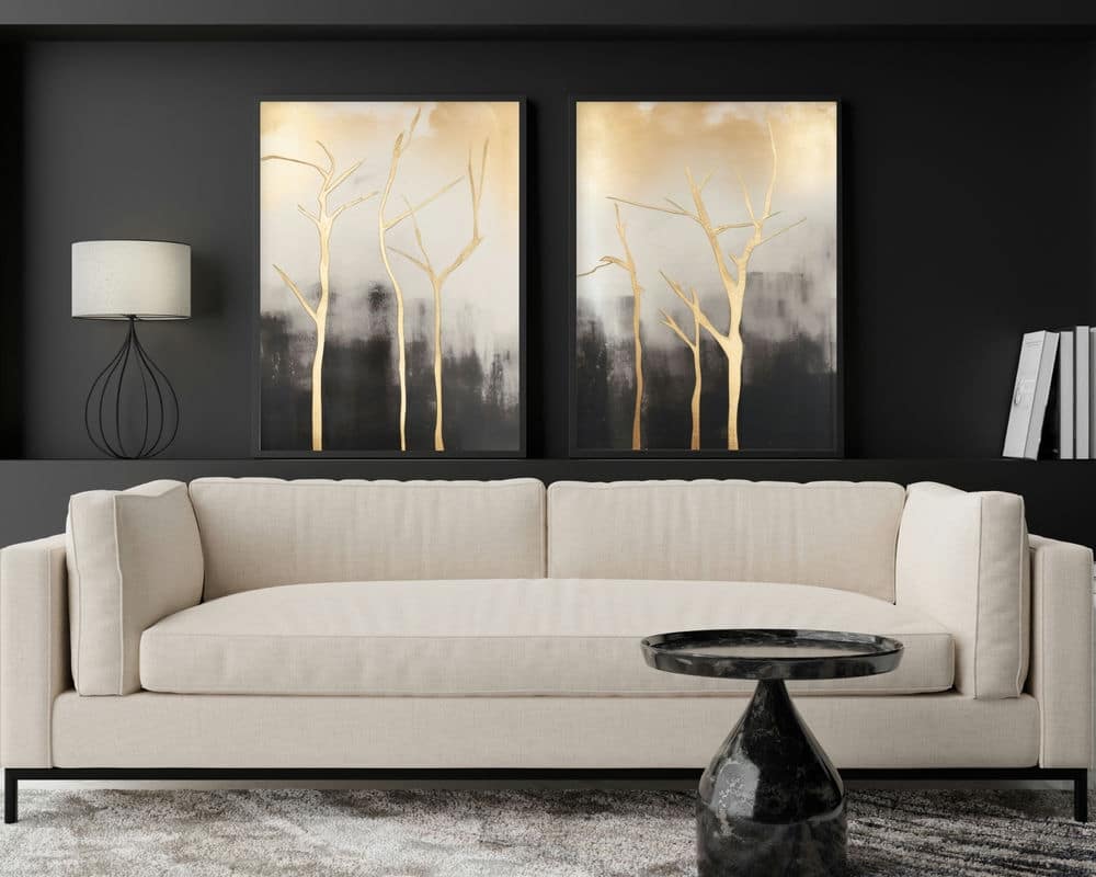 סלון מודרני המציג ספה מרופדת לבנה על קיר כהה, מעוטר סט 2 תמונות לסלון נוסח אבסטרקט ענבים בזהב ושחור מעליו. בחזית הספה יושב שולחן קפה משיש שחור, כאשר משמאל ניצבת מנורה מסוגננת עם מסגרת תיל.