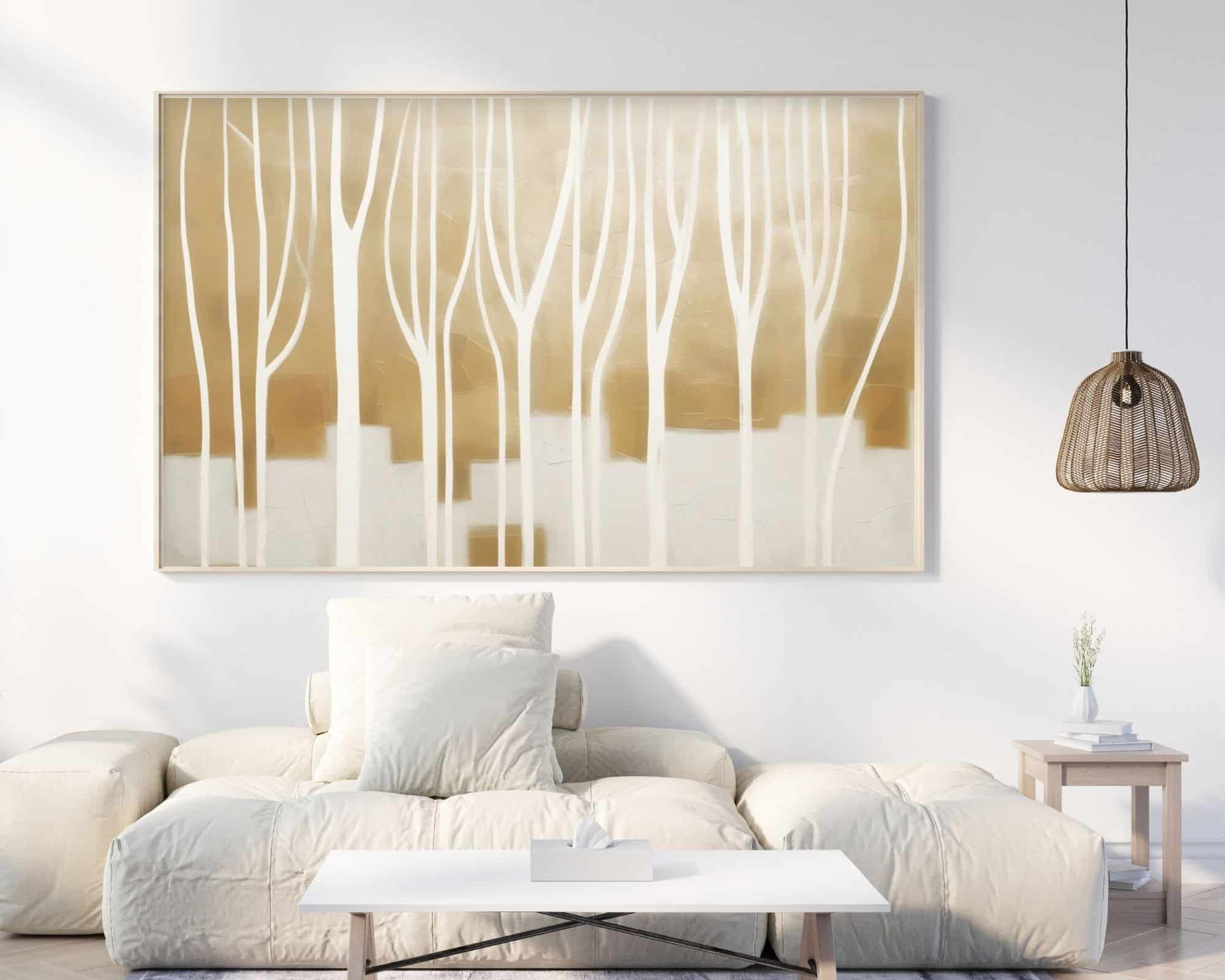 2475mo1 סלון מינימליסטי כולל ספה לבנה עם כריות מרובות, שולחן קפה לבן נמוך, ויצירת אמנות מודרנית ממוסגרת בשם "תמונה מעל המיטה נוסח אבסטרקט ענפים על רקע זהב ולבן" המתארת עצים גבוהים מופשטים בגווני לבן ובז' על הקיר. מנורת נצרים תלויה ושולחן צד קטן עם צמח נמצאים גם כן.