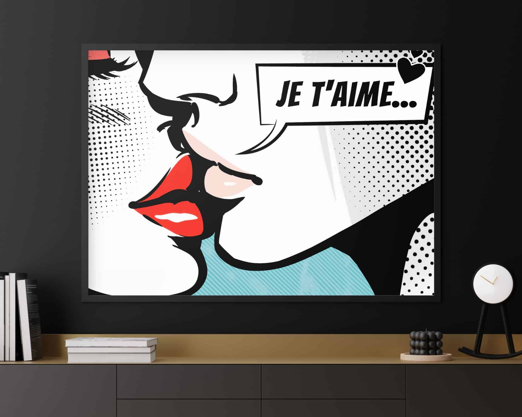 2498mo1 תמונה ממוסגרת בסגנון פופ ארט שכותרתה "תמונה לסלון מעל הספה נוסח פופ ארט זוג בנשיקה" תלויה על קיר שחור, המתארת תקריב של פניה של אישה עם שפתיים אדומות ובועת דיבור האומרת "Je t'aime... " בצרפתית. מתחת לתמונה מוערמים ספרים ושעון עגול על מדף.