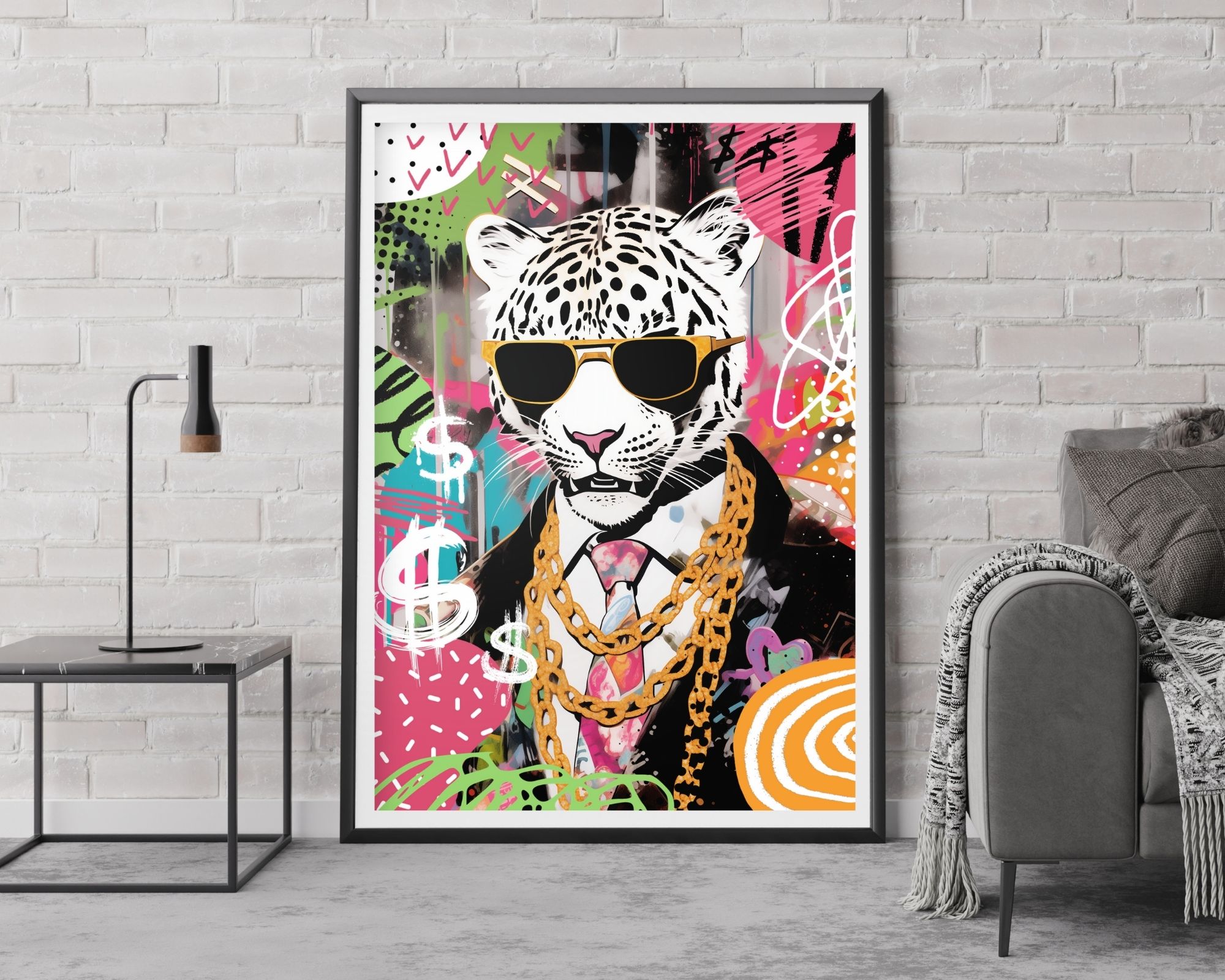 2513mo1 על קיר לבנים לבנים מוצגת "תמונה לחדר נוער נוסח פופ ארט טיגריס קינג בעיצוב צבעוני" ממוסגרת הכוללת נמר לבוש בחליפה, משקפי שמש ושרשראות זהב. הרקע הצבעוני בסגנון גרפיטי מציג שלטי דולרים וצורות מופשטות. התמונה ממוקמת ליד ספה אפורה ושולחן צד מודרני עם אגרטל.