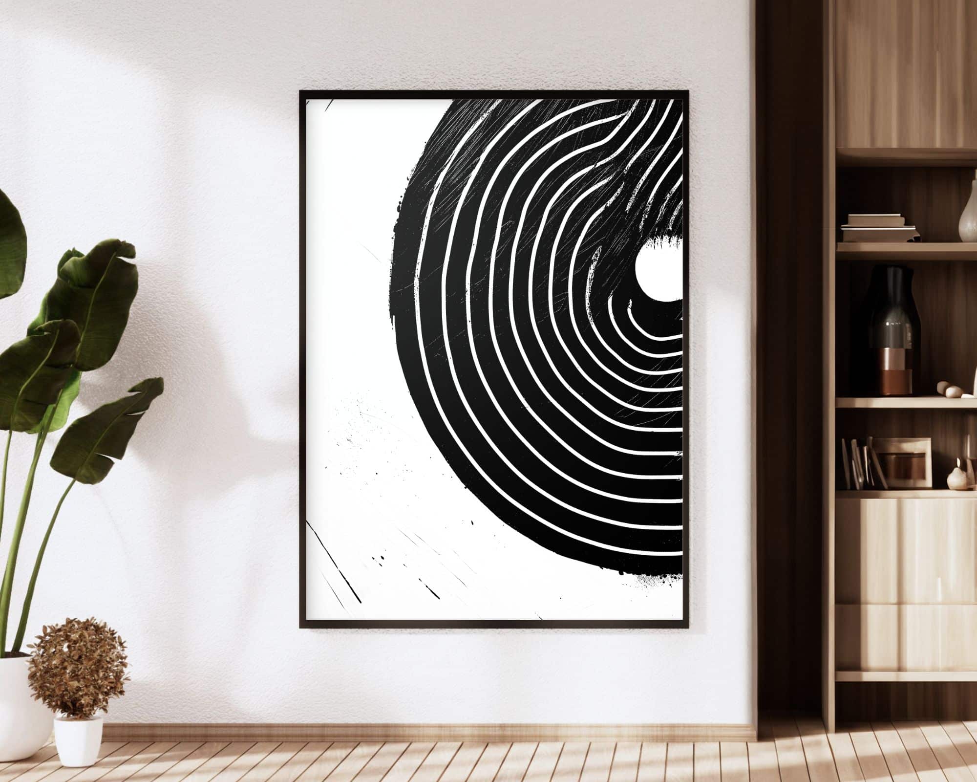 2546mo1 חדר מודרני ומינימליסטי כולל יצירות אמנות מופשטות ממוסגרות "תמונה למשרד בעיצוב מינימליסטי עיגול שחור עם קווים לבנים" על הקיר. היצירה מורכבת מעיגולים קונצנטריים עם מרקם מחוספס. צמח גבוה ניצב משמאל, ומימין מדף עץ עם פריטי נוי.