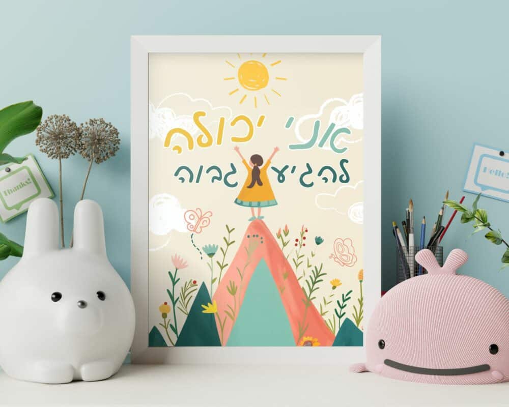 איור ממוסגר בשם "תמונה לחדר ילדים משפטי השראה מוטיבציה ילדה על הר", המתאר ילדה עומדת על הר תחת שמש זוהרת עם טקסט בעברית. המסגרת מונחת על שולחן לצד אגרטל לבן בצורת ארנבת, עציצים, כלי כתיבה שונים וצעצוע קטיפה ורוד.