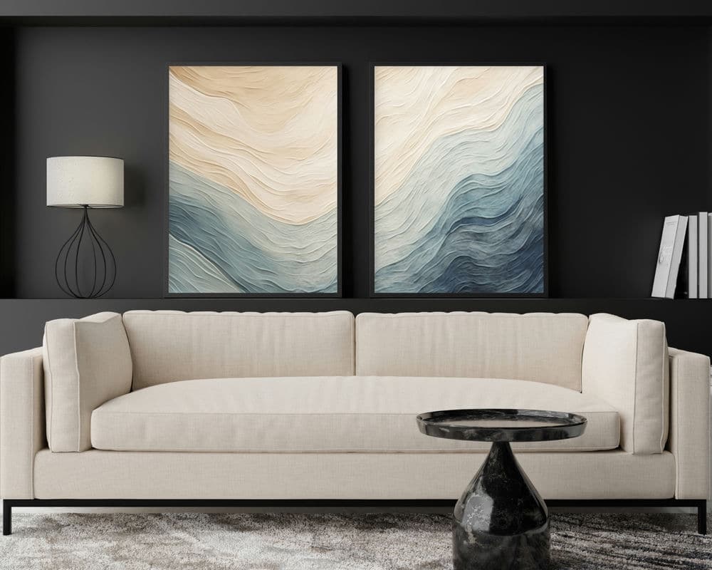 2445mo0V2 סלון מודרני כולל ספה בצבע בז' על קיר אפור כהה. מעל הספה תלויים שני חלקים מקולקציית וכחול של סט 2 תמונות לסלון נוסח אבסטרקט גלים בז, המציגות טקסטורות גליות בגווני שזוף, שמנת, כחול וצהבהב. בחזית הספה יושב שולחן קפה משיש שחור עגול, כאשר משמאל ניצבת מנורה עם בסיס מסגרת תיל.